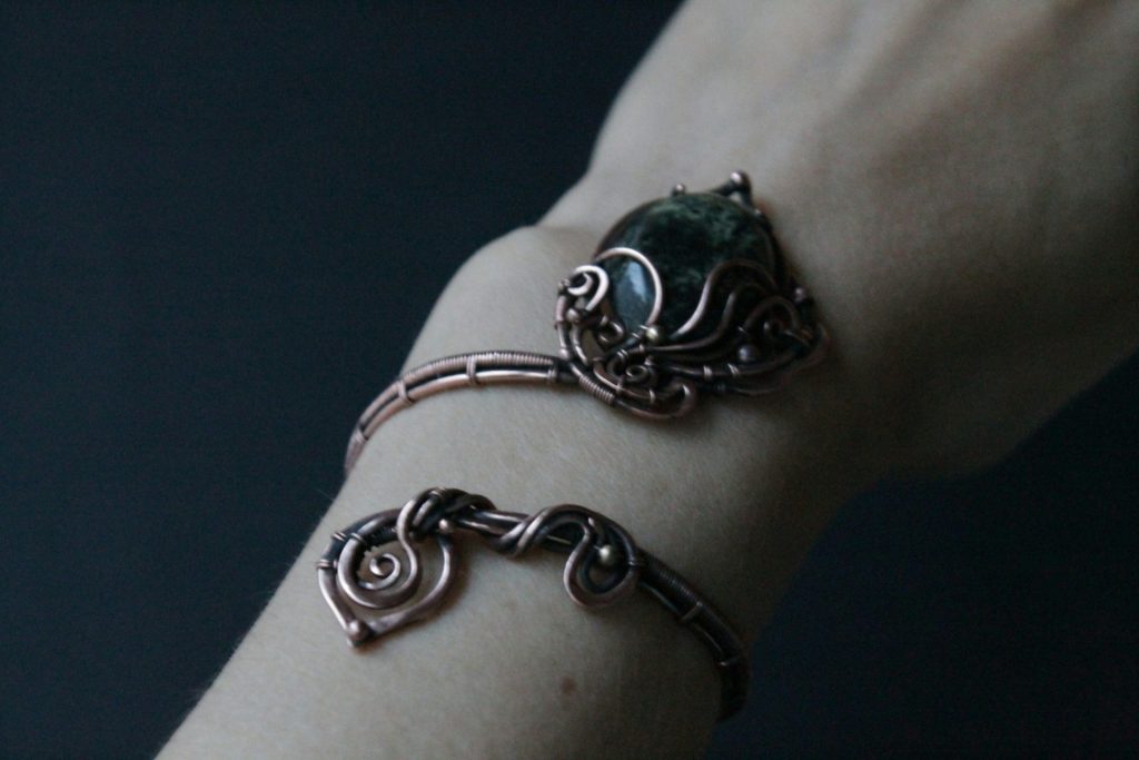 a woman's arm with two bracelets on it